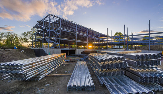 A steel structure under construction at sunset.